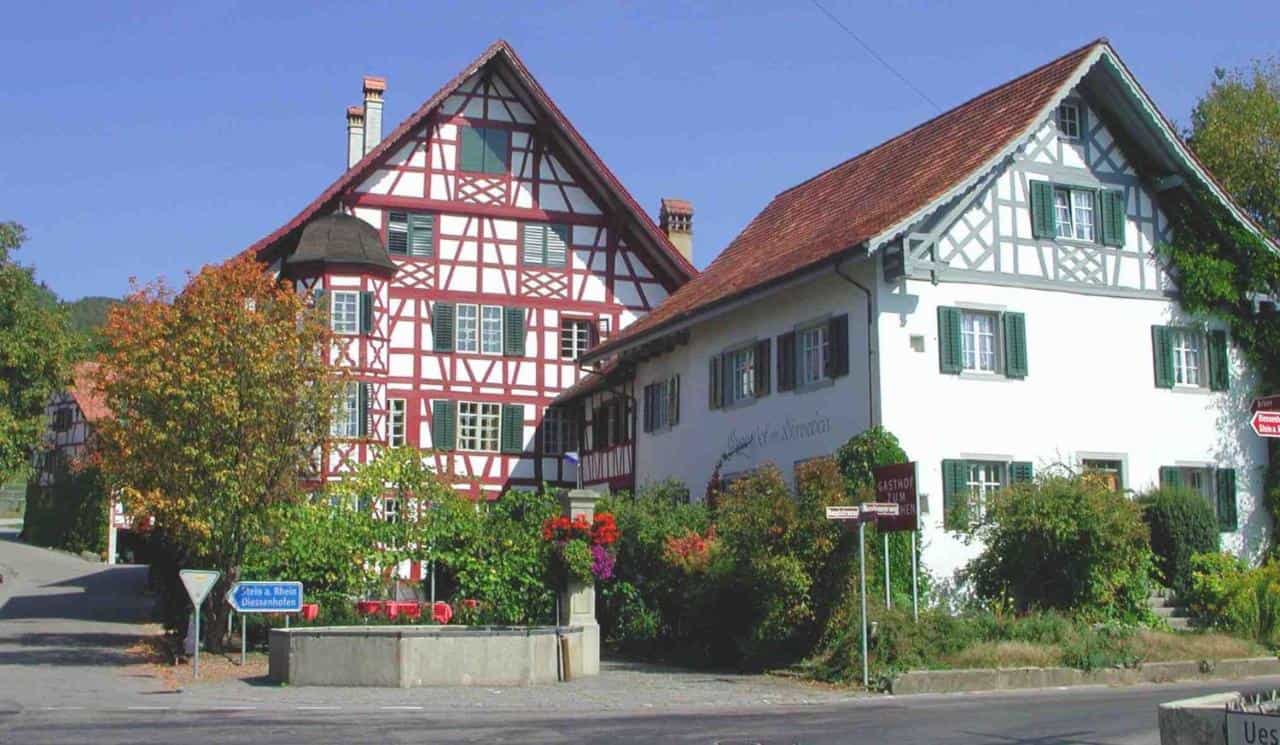 Half-timbered buildings in Stein am Rhein, including Gasthof Hirschen Stammheim, with autumn foliage.