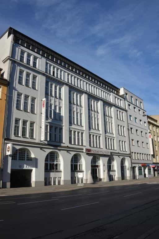 Art Hotel Munich building facade with arched ground floor windows on a sunny day.