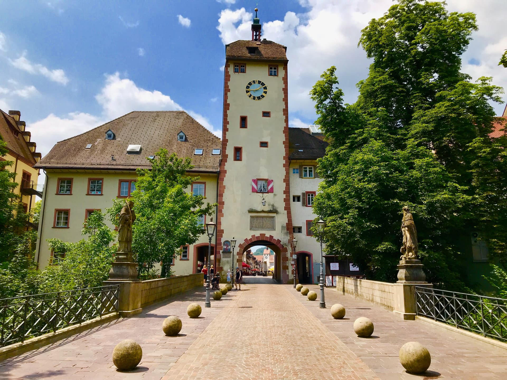 Clock tower gatehouse entrance in Waldshut with stone bollards on a sunny day.
