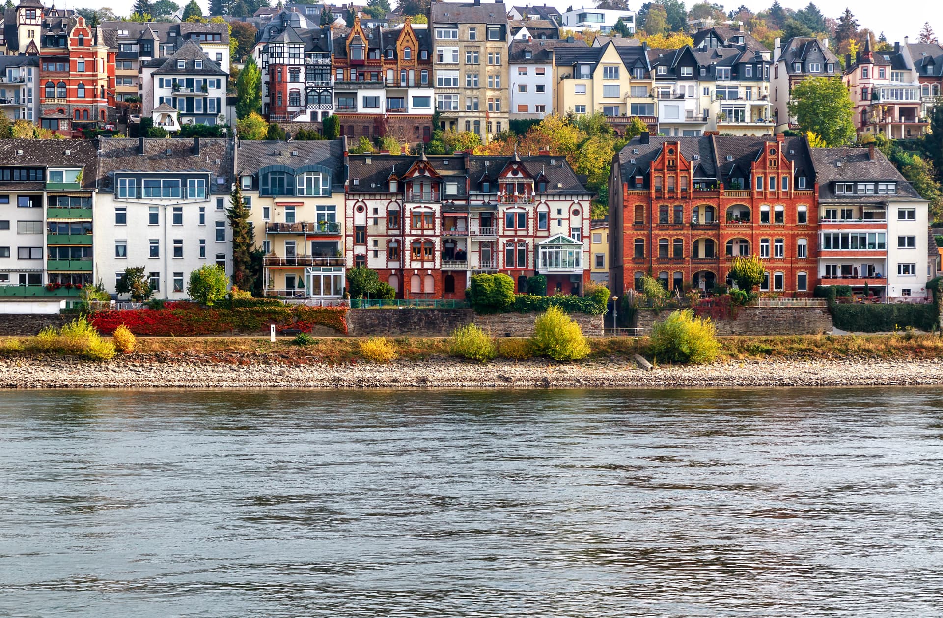 Colorful buildings on hillside above river in Koblenz with autumn foliage